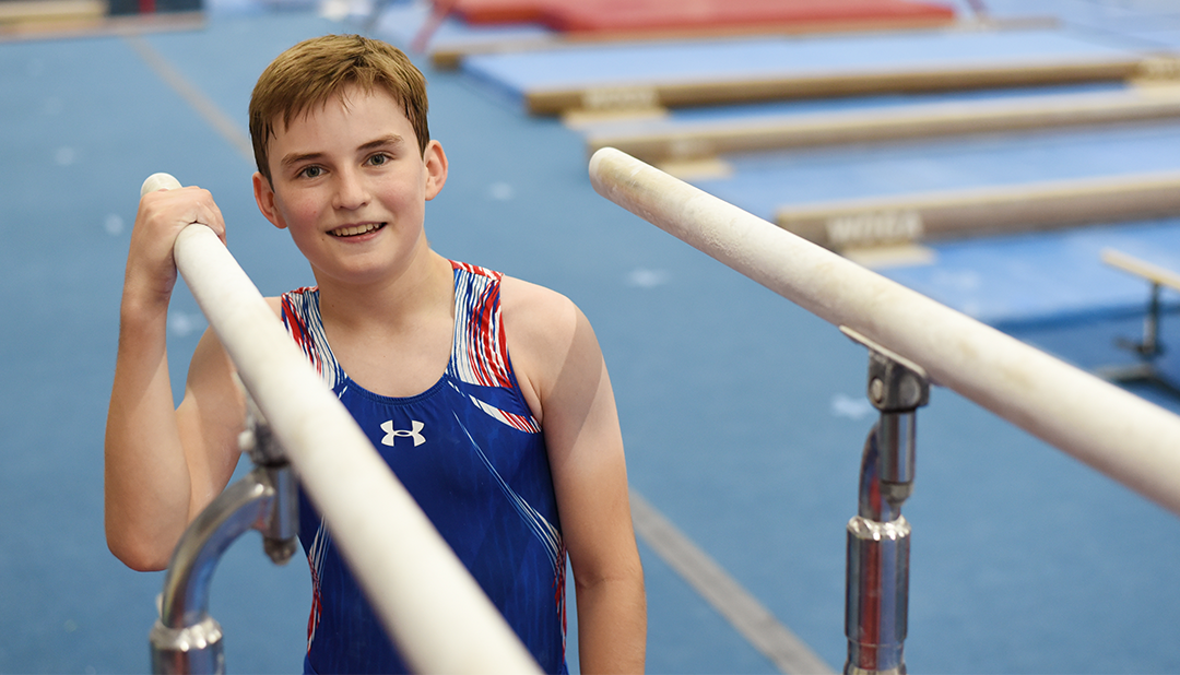 A young boy stands on bars