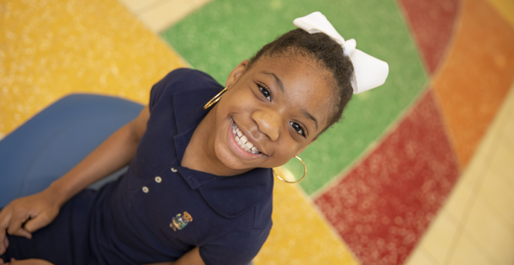 Smiling girl on vibrant floor.