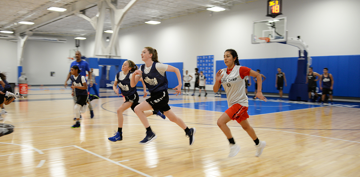 Young athletes running in basketball practice.