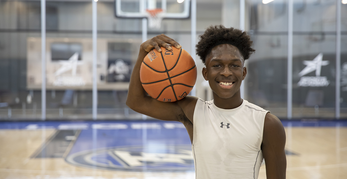 teen male in gym playing basketball