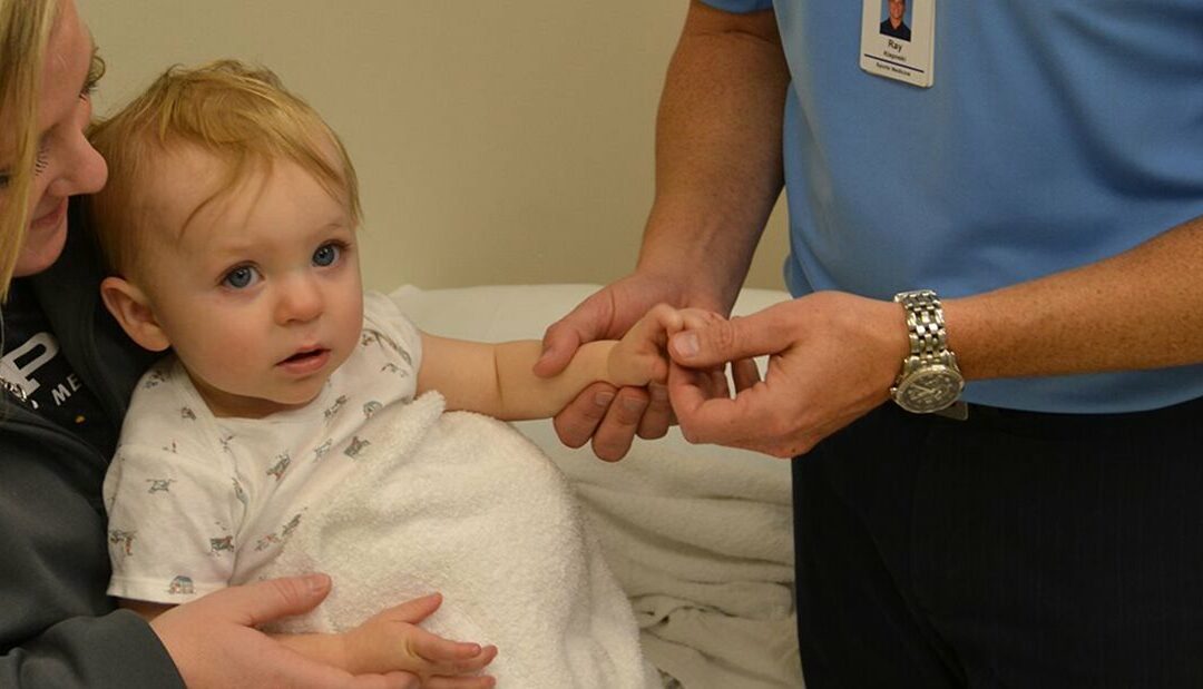 Doctor examines child's hand