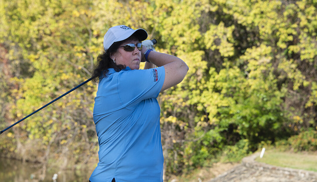 woman swinging golf club