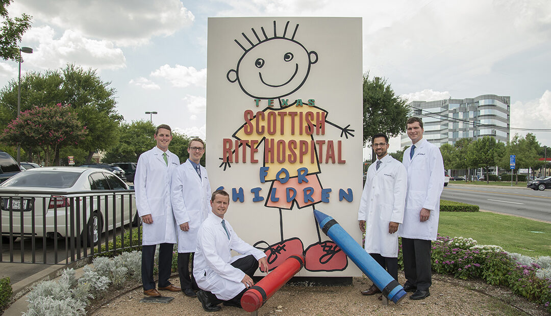 Fellows around hospital signage.