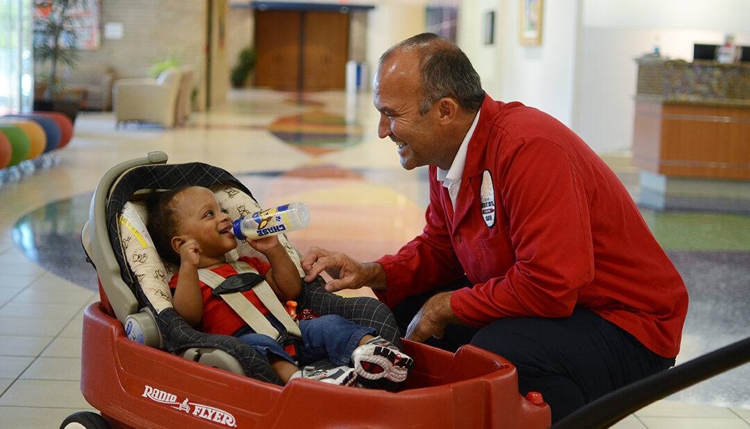 volunteer with patient in wagon in hall