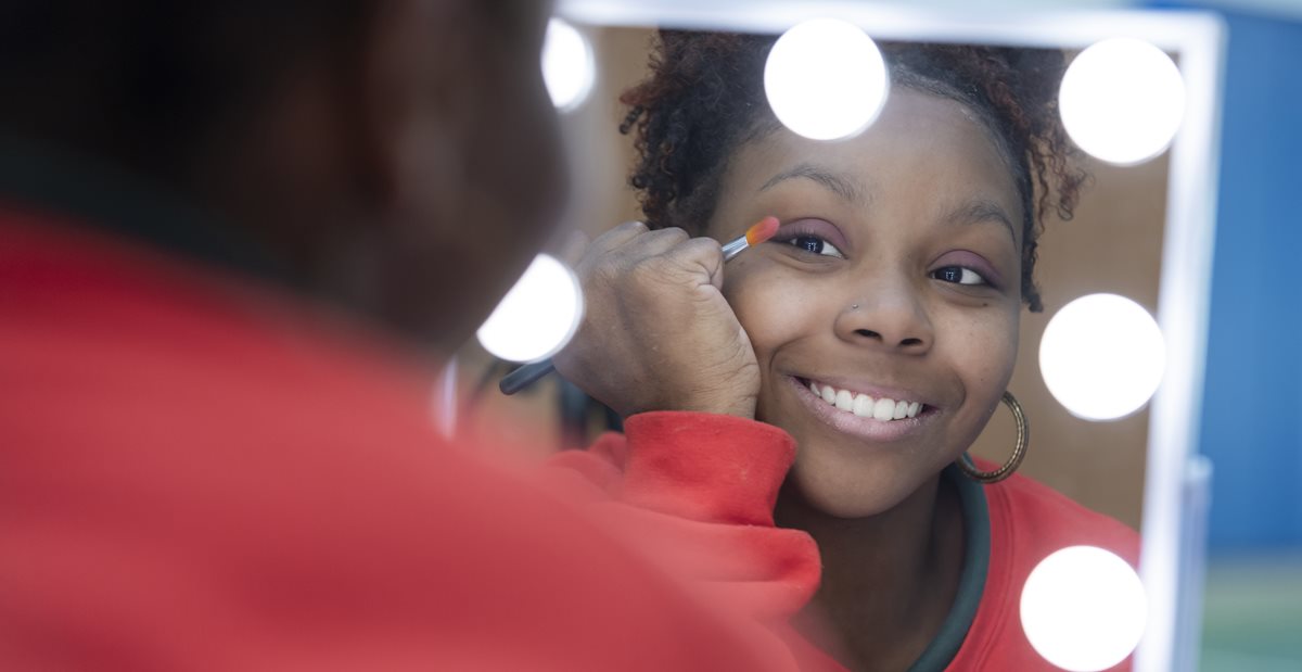 Zion, patient with cerebral palsy, putting on make up in occupational therapy